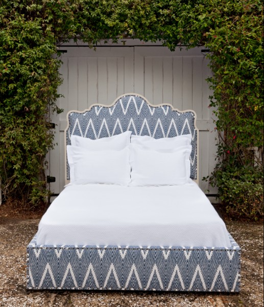 blue and white geometric fabric bed with white wood accents