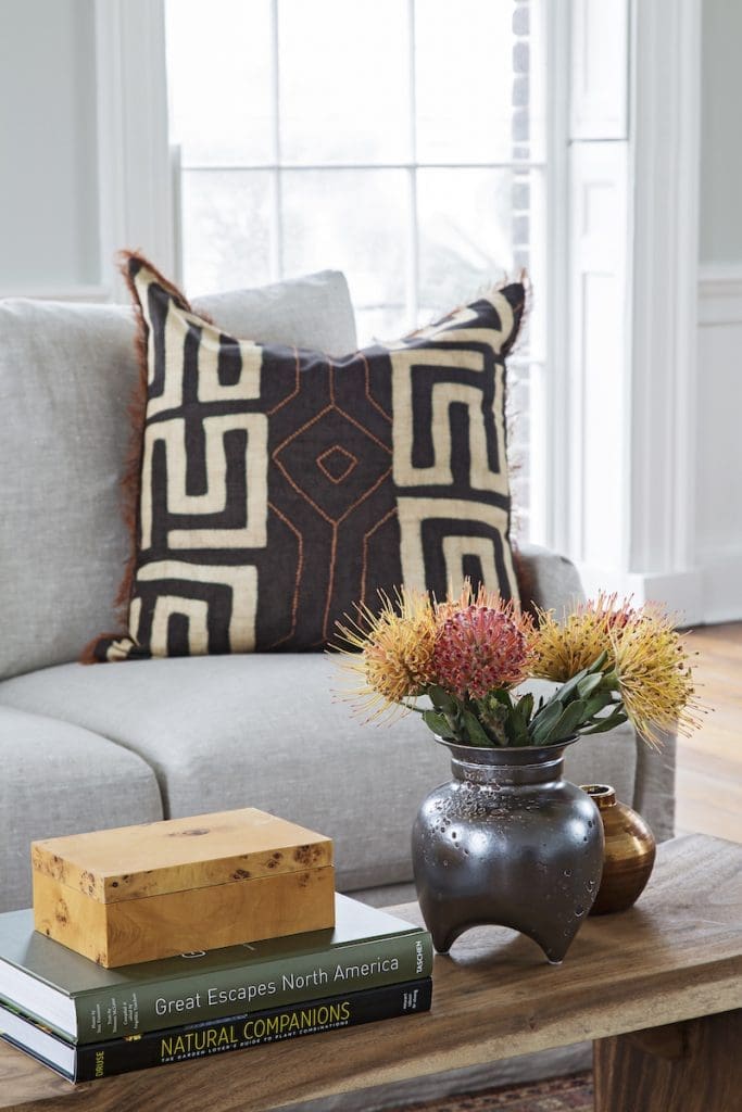 Dark patterned accent pillow paired with a wood table by Mt Pleasant furniture store GDC